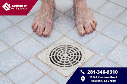 Feet near a shower drain while water falls.